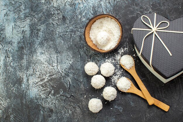 Vista dall'alto deliziose palline di cocco con il giorno di San Valentino presente su sfondo scuro dolce biscotto caramella colore lattiero-caseario