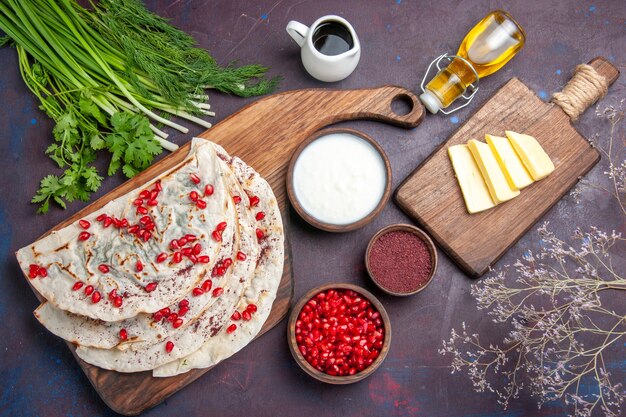 Vista dall'alto deliziose pitas qutabs di carne con melograni rossi freschi sulla superficie scura pasta pasto pasto pita