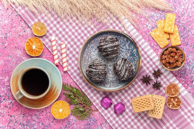 Vista dall'alto deliziose torte al cioccolato con tè e cialde sul rosa