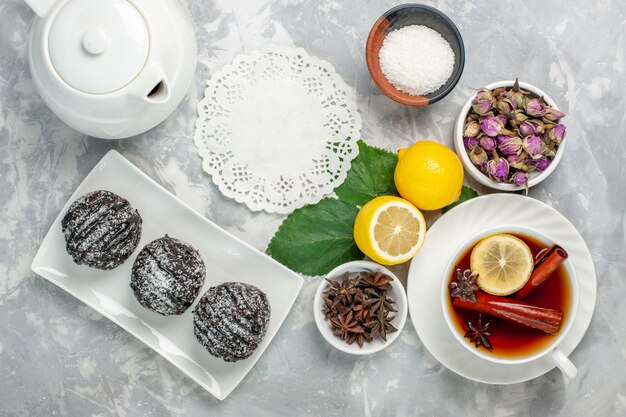 Vista dall'alto deliziose torte al cioccolato piccolo tondo formato con il limone sulla scrivania bianca frutta torta biscotto zucchero dolce cuocere biscotto