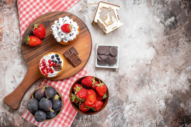 Vista dall'alto deliziose torte con frutta fresca su sfondo chiaro