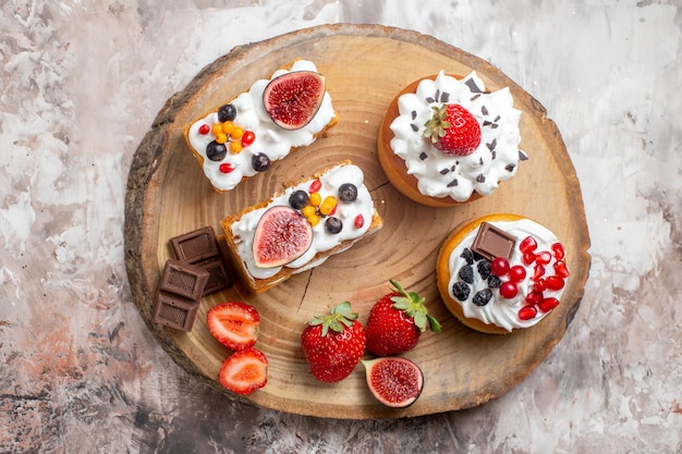 Vista dall'alto deliziose torte con frutta fresca su sfondo chiaro