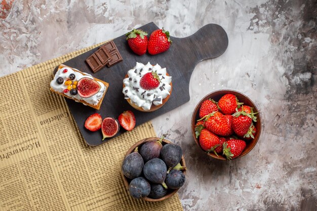 Vista dall'alto deliziose torte con frutta fresca su sfondo chiaro