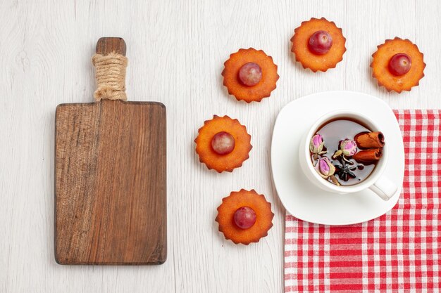 Vista dall'alto deliziose torte con una tazza di tè sulla scrivania bianca frutta tè dessert biscotti torta biscotto torta