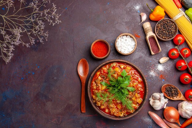 Vista dall'alto deliziose verdure cotte affettate con verdure e condimenti sulla salsa di cibo pasto zuppa sfondo scuro