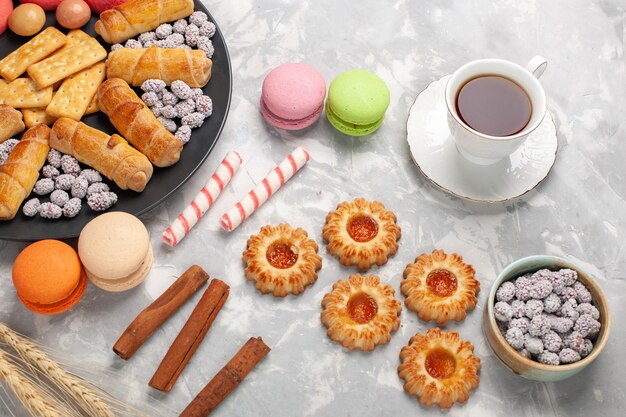 Vista dall'alto deliziosi bagel con cracker cannella macarons e biscotti sulla scrivania bianca torta biscotto dolce zucchero torta biscotto croccante