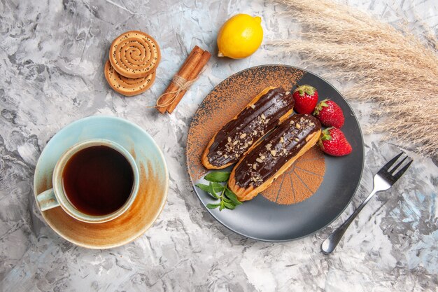 Vista dall'alto deliziosi bignè al cioccolato con una tazza di tè sulla torta di biscotti da dessert da tavola leggera