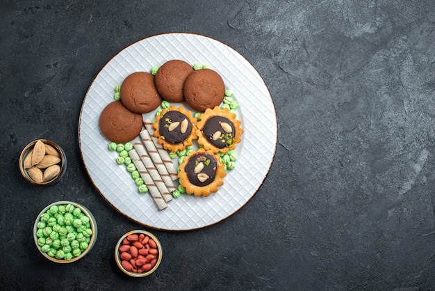 Vista dall'alto deliziosi biscotti con diverse caramelle su sfondo grigio scuro zucchero biscotto torta dolce torta tè biscotto