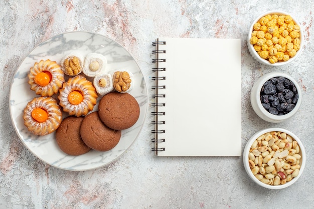 Vista dall'alto deliziosi biscotti con noci e uvetta su sfondo bianco biscotto con noci zucchero dolce per dolci