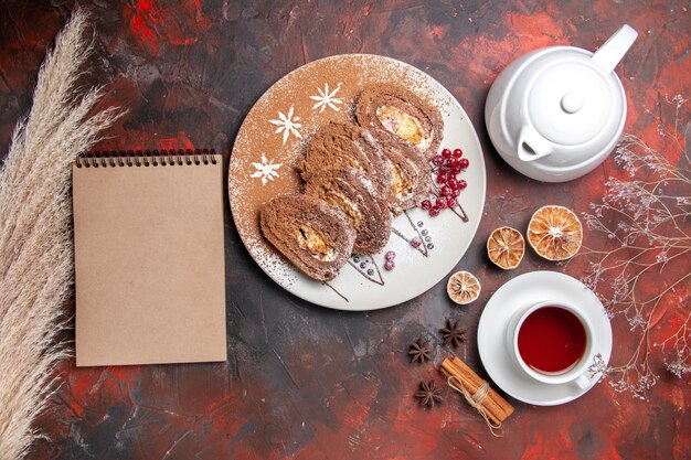 Vista dall'alto deliziosi biscotti con una tazza di tè sul tavolo scuro