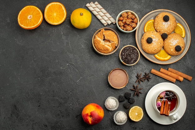 Vista dall'alto deliziosi biscotti con una tazza di tè sulla torta di biscotti al biscotto del tè della scrivania scura