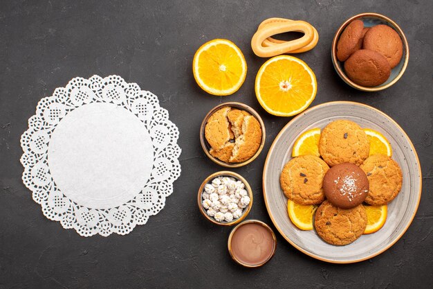 Vista dall'alto deliziosi biscotti di sabbia con arance a fette sullo sfondo scuro biscotto di agrumi di frutta biscotto di torta dolce