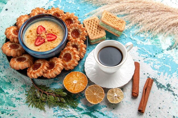 Vista dall'alto deliziosi biscotti di zucchero con cialde tazza di caffè e dessert alla fragola sulla superficie blu biscotto biscotto torta dolce colore