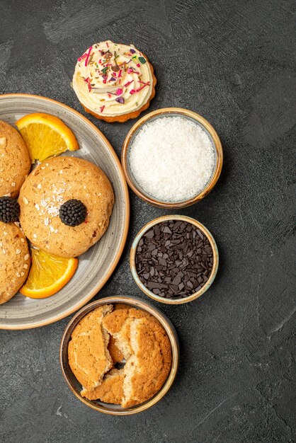 Vista dall'alto deliziosi biscotti di zucchero con fette d'arancia su superficie scura biscotto biscotto dolce torta al tè