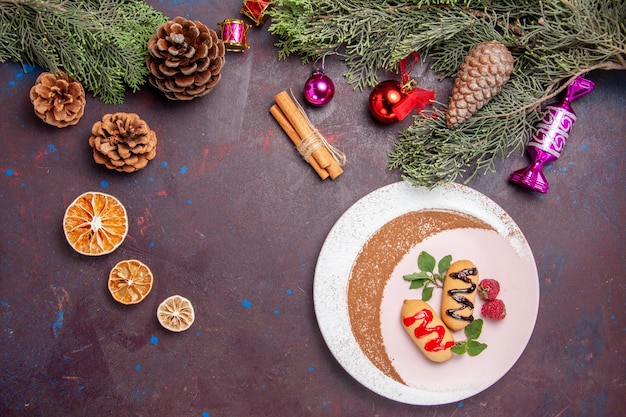 Vista dall'alto deliziosi biscotti dolci con giocattoli di natale su sfondo scuro biscotto biscotto dolce torta color zucchero