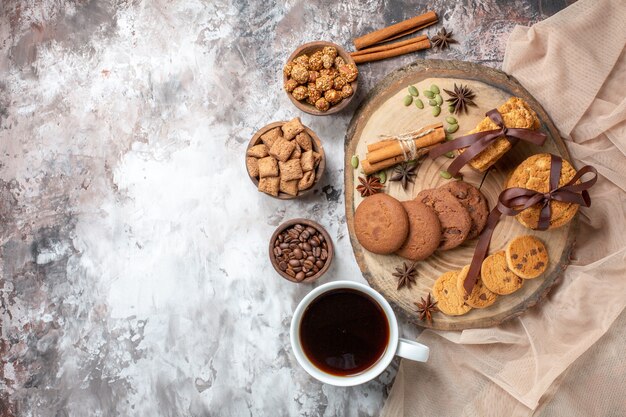 Vista dall'alto deliziosi biscotti dolci con una tazza di caffè sul tavolo luminoso