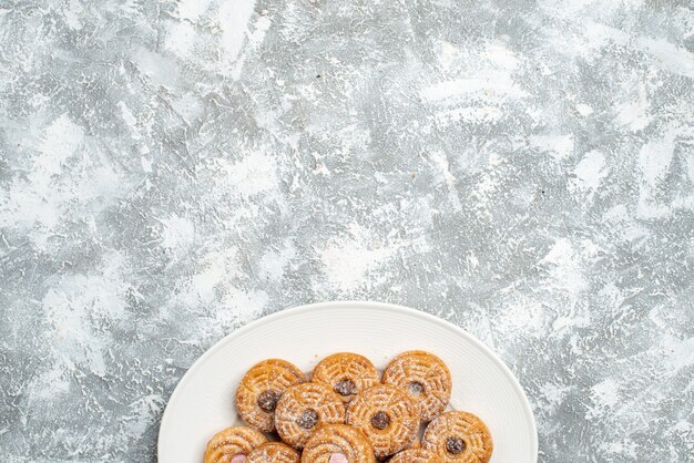 Vista dall'alto deliziosi biscotti rotondi all'interno del piatto su uno spazio bianco