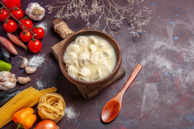 Vista dall'alto deliziosi gnocchi con diversi condimenti sull'impasto di salsa cena cena a base di carne sfondo scuro