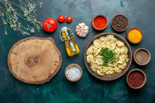 Vista dall'alto deliziosi gnocchi con diversi condimenti sulla superficie verde scuro pasta pasto carne verdure cena pasticceria