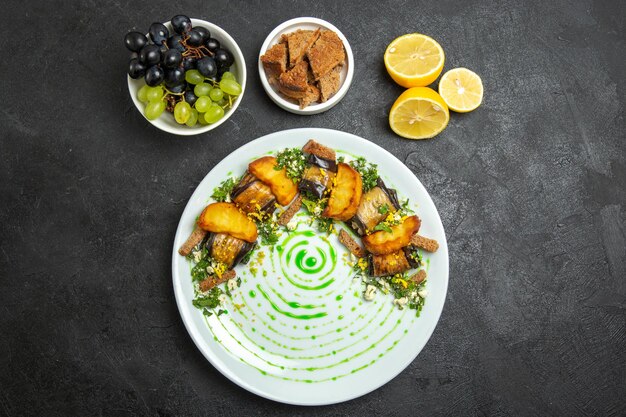 Vista dall'alto deliziosi involtini di melanzane con patate al forno all'interno del piatto sullo sfondo scuro piatto cena cibo patate verdure