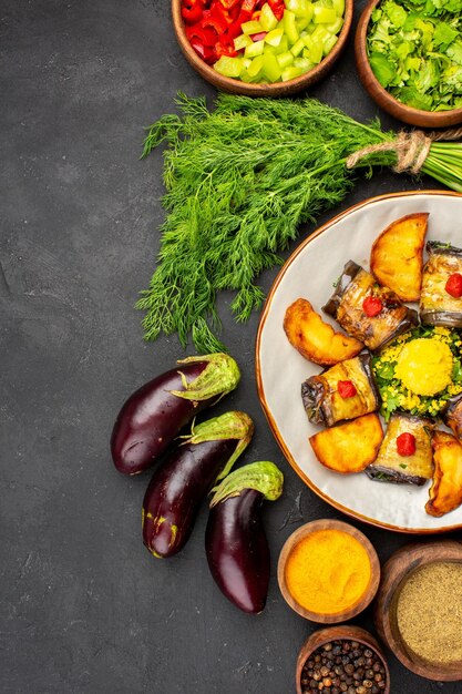 Vista dall'alto deliziosi involtini di melanzane piatto cotto con condimenti di patate su sfondo scuro piatto da cucina cibo fritto di patate al forno