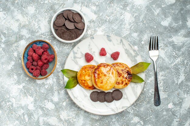 Vista dall'alto deliziosi muffin con miele e biscotti al cioccolato su sfondo chiaro