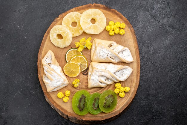 Vista dall'alto deliziosi pasticcini con fette di frutta secca sullo spazio grigio