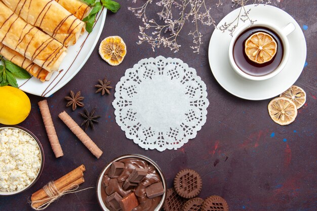 Vista dall'alto deliziosi pasticcini dolci con limone e cioccolato su uno spazio buio