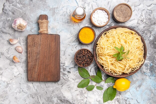 Vista dall'alto deliziosi spaghetti con condimenti su pasta bianca da tavola