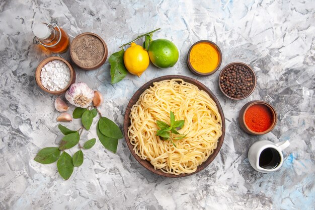 Vista dall'alto deliziosi spaghetti con condimenti su pasta bianca da tavola