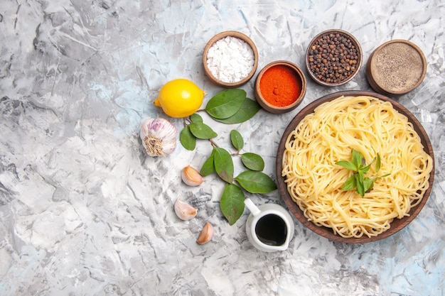 Vista dall'alto deliziosi spaghetti con condimenti su tavola bianca cena pasta pasto pasta