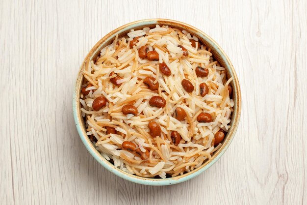 Vista dall'alto deliziosi vermicelli cotti con fagioli sulla scrivania bianca pasto cucinando piatto di pasta di fagioli