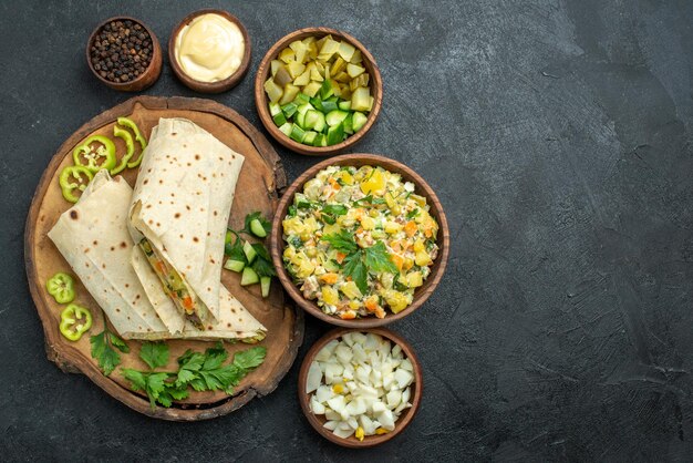 Vista dall'alto delizioso panino con insalata shaurma affettato su superficie grigia pasto pita panino hamburger insalata