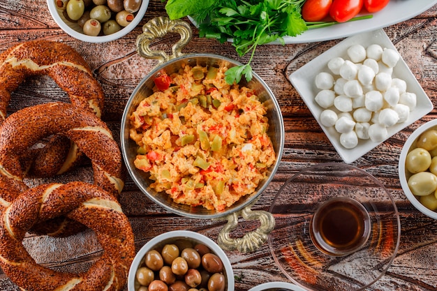 Vista dall'alto delizioso pasto nel piatto con bagel turco, una tazza di tè, insalata, sottaceti su superficie di legno