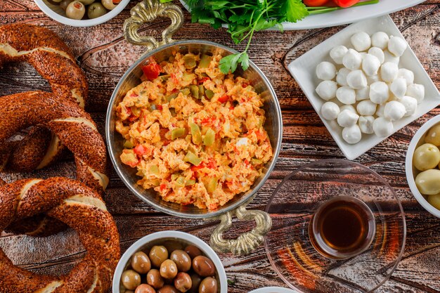 Vista dall'alto delizioso pasto nel piatto con bagel turco, una tazza di tè, insalata, sottaceti su superficie di legno