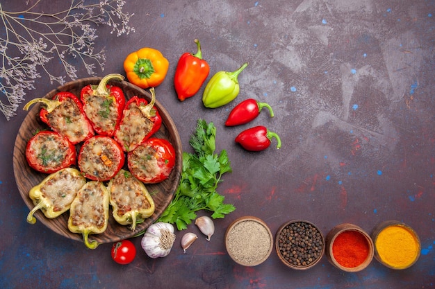 Vista dall'alto delizioso piatto al forno di peperoni con carne tritata e verdure su sfondo scuro piatto di carne cena cuocere il pasto