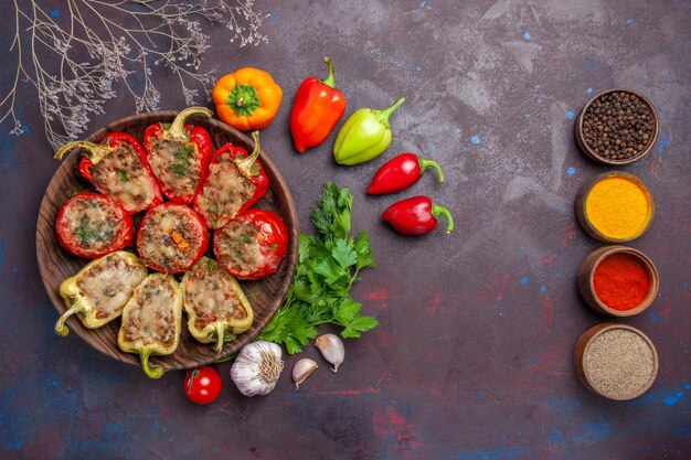 Vista dall'alto delizioso piatto al forno di peperoni con carne tritata e verdure su tavola scura cena cibo cuocere carne piatto di sale