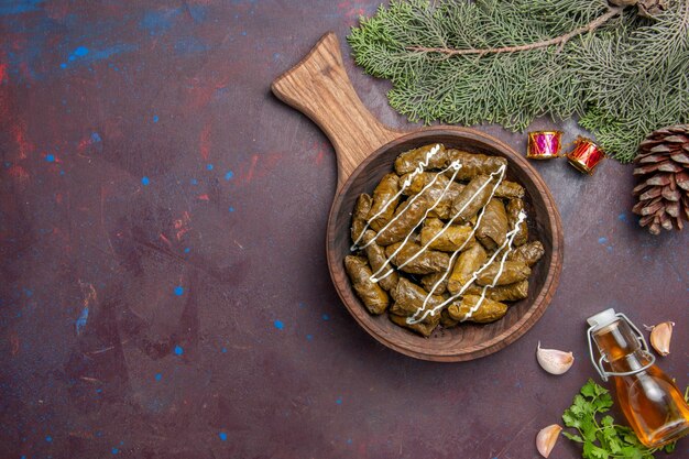 Vista dall'alto delizioso piatto di carne di dolma a foglia con diversi condimenti su piatto scuro per cena a base di carne cibo calorie colore