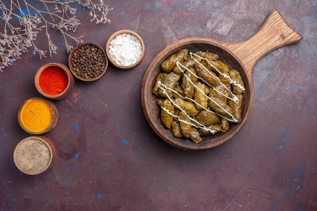 Vista dall'alto delizioso piatto di carne dolma con diversi condimenti su uno sfondo scuro piatto per cena cibo caloria di carne