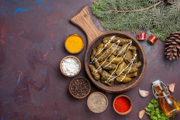 Vista dall'alto delizioso piatto di carne dolma foglia con condimenti su sfondo scuro piatto di carne piatto cibo calorie colore