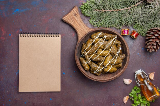 Vista dall'alto delizioso piatto di carne dolma foglia con diversi condimenti su sfondo scuro piatto di carne cibo calorie colore