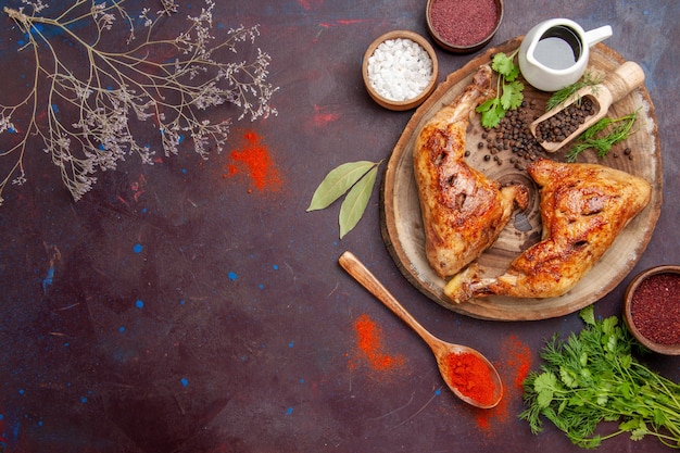 Vista dall'alto delizioso pollo fritto con diversi condimenti sulla scrivania scura