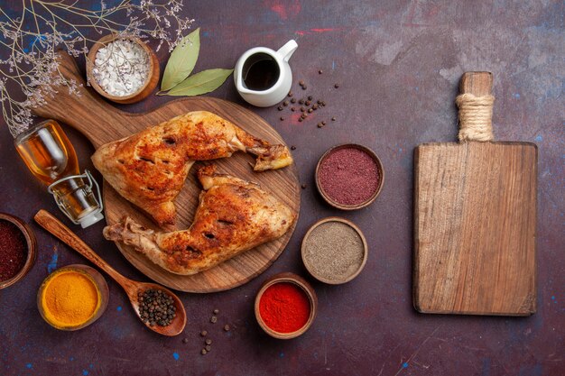 Vista dall'alto delizioso pollo fritto con diversi condimenti sulla scrivania scura