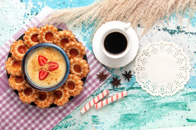 Vista dall'alto delizioso zucchero con tazza di caffè e dessert alla fragola su superficie azzurra