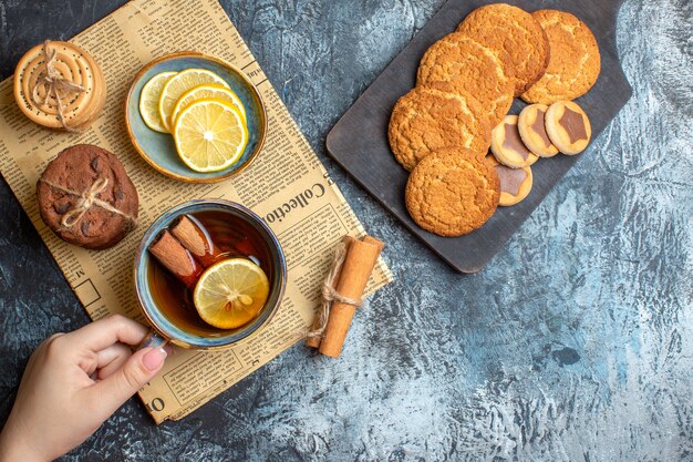 Vista dall'alto dell'ora del tè con deliziosi biscotti alla cannella al limone su un vecchio giornale