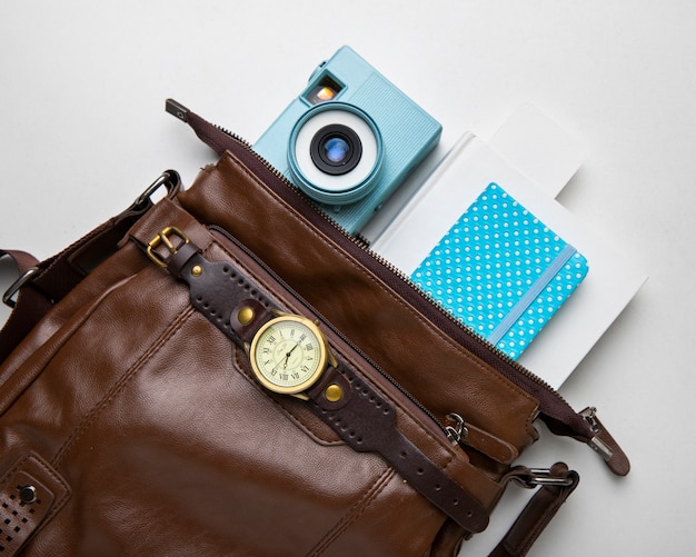 Vista dall'alto della borsa in pelle da viaggio con fotocamera e notebook