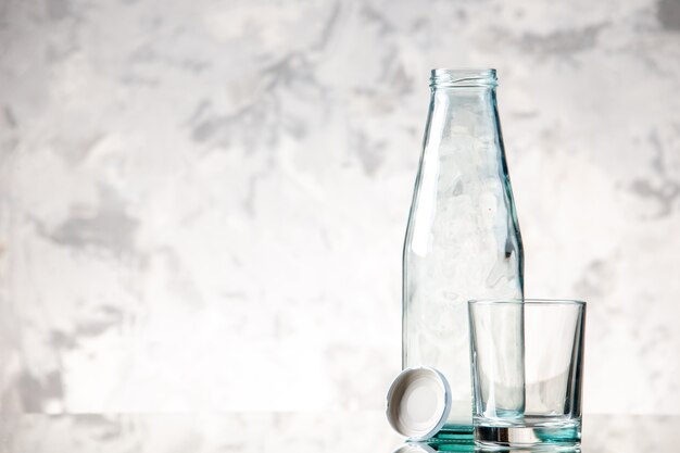 Vista dall'alto della bottiglia vuota e tappare un bicchiere sul lato sinistro sulla parete di ghiaccio con spazio libero