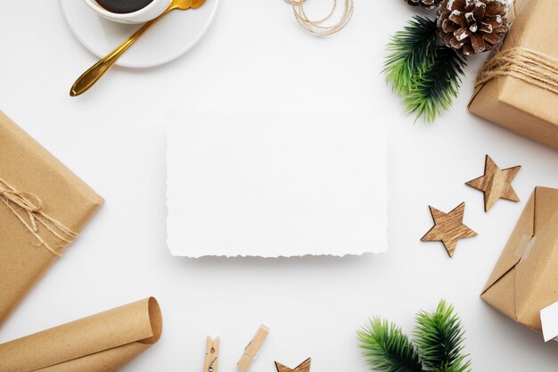 Vista dall'alto della composizione in Natale con confezione regalo, nastro, rami di abete, coni, anice sul tavolo bianco