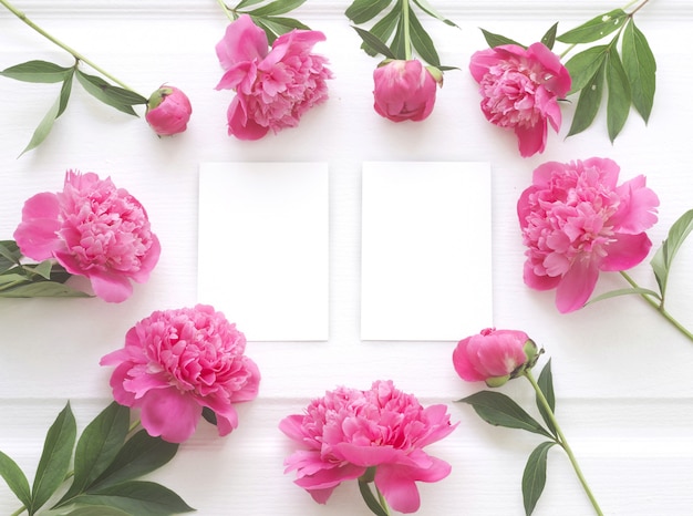 Vista dall'alto della cornice di fiori di peonia con carta bianca chiara