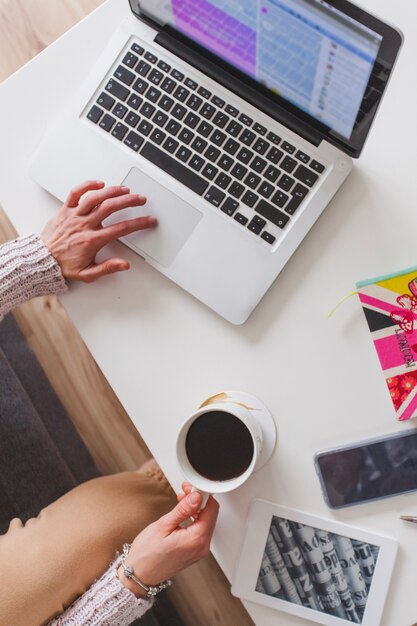 Vista dall&#39;alto della donna con il computer portatile e il caffè